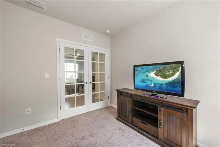 Unfurnished living room with french doors, carpet, and visible vents