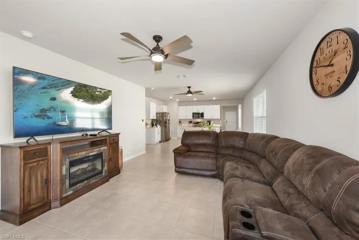 Living area featuring a ceiling fan, visible vents, recessed lighting, light tile patterned flooring, and baseboards