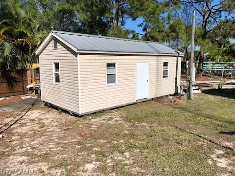 View of outbuilding with a lawn