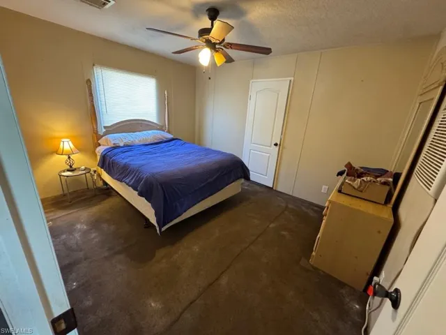 Bedroom featuring ceiling fan and a textured ceiling