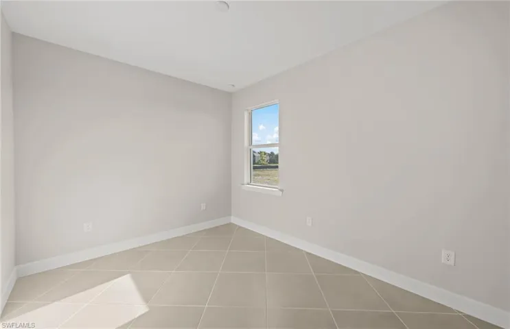Spare room featuring baseboards and light tile patterned floors