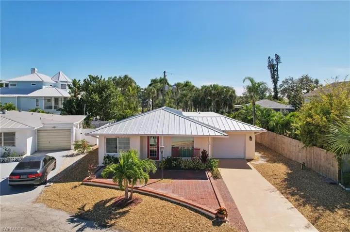 View of front of house featuring driveway, a metal roof, a garage, and a standing seam roof