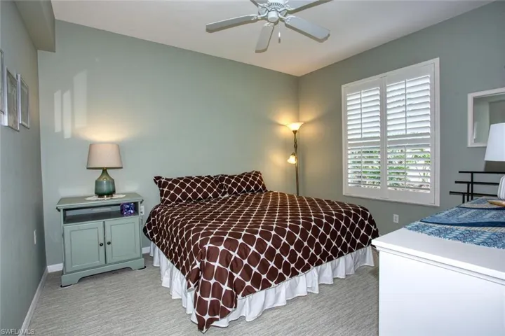 Bedroom with ceiling fan and light carpet