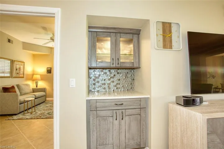 Bar with light tile patterned floors and ceiling fan