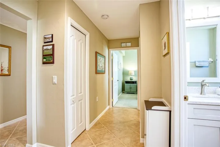 Hallway featuring sink and light tile patterned floors