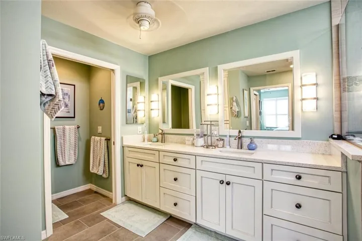 Bathroom with hardwood / wood-style floors, ceiling fan, and vanity