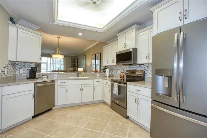 Kitchen featuring sink, decorative backsplash, appliances with stainless steel finishes, and ornamental molding