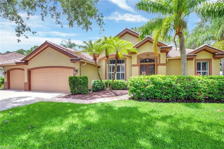 Mediterranean / spanish home with a front yard and a garage