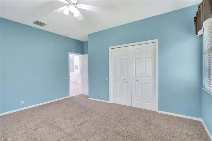 Unfurnished bedroom with carpet, ceiling fan, and a closet