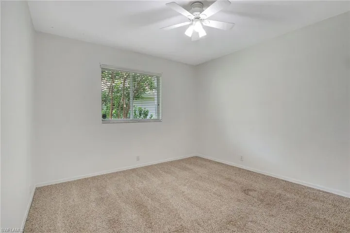 Empty room with ceiling fan and carpet flooring