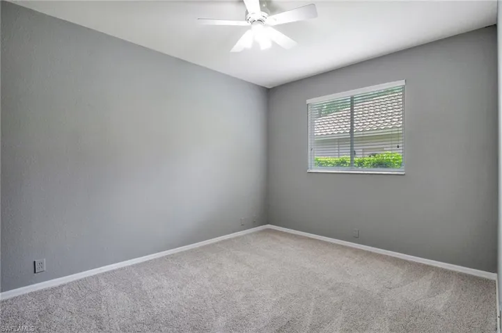 Carpeted empty room with ceiling fan