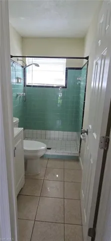 Full bathroom featuring a stall shower, vanity, and tile patterned flooring
