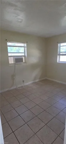 Spare room with baseboards and cooling unit