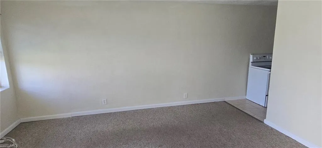 Spare room featuring light carpet and washer / dryer