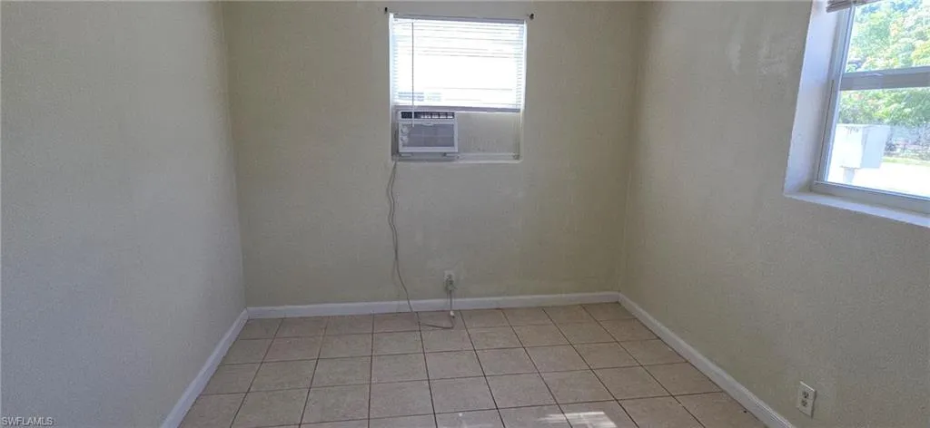 Empty room with baseboards and light tile patterned floors