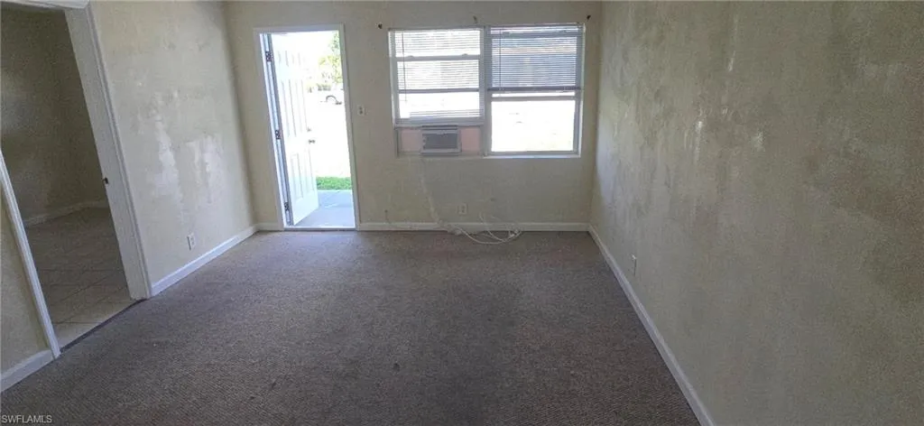 Empty room featuring carpet and baseboards