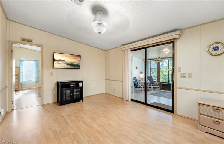 Unfurnished living room featuring light wood-type flooring, a textured ceiling, ceiling fan, and visible vents