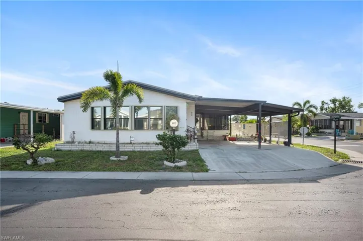 Manufactured / mobile home featuring an attached carport and driveway