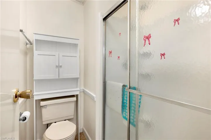 Bathroom with a shower stall and toilet