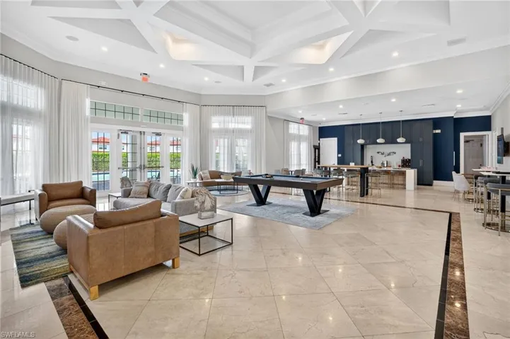 Spacious common area featuring coffered ceilings with recessed lighting, large format tile flooring, and multiple sets of French doors with transom windows