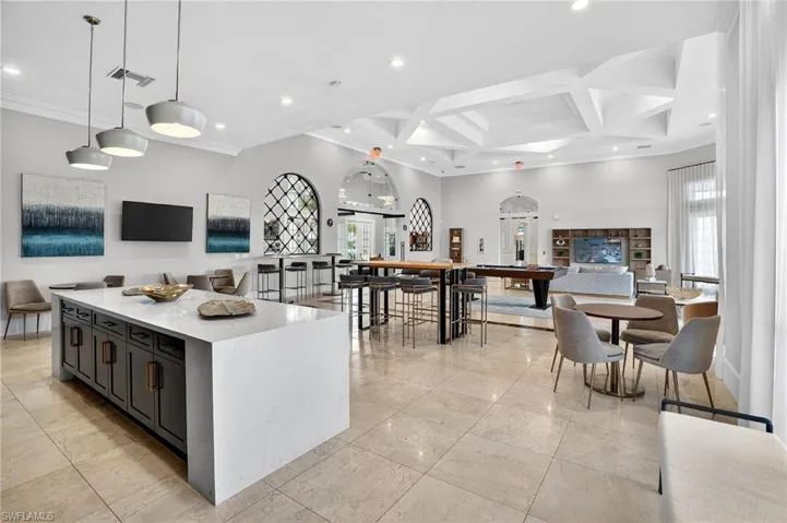 Spacious common area featuring large format tile flooring, a geometric coffered ceiling, and pendant lighting