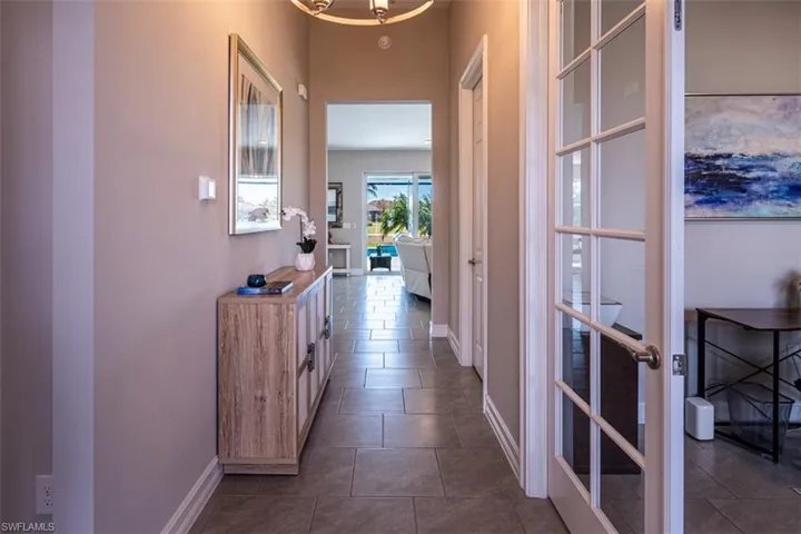 Corridor featuring dark tile patterned flooring and hanging lights