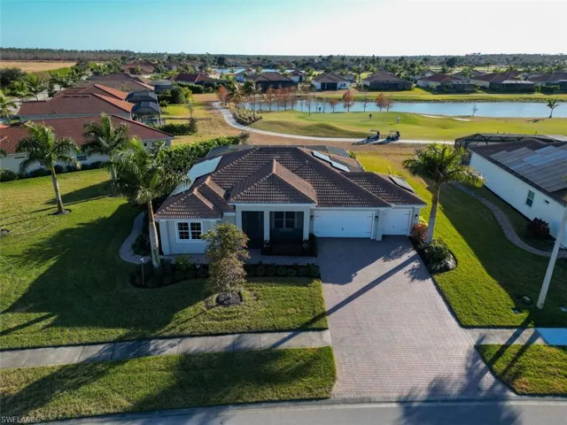 Aerial perspective of suburban area featuring a nearby body of water