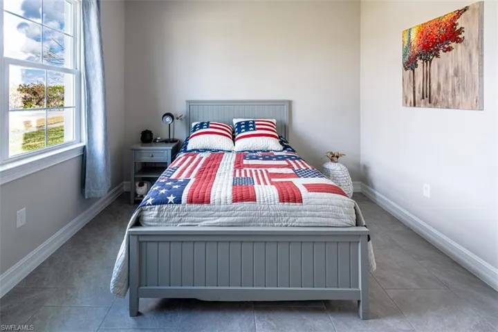 Bedroom with baseboards and light tile patterned floors