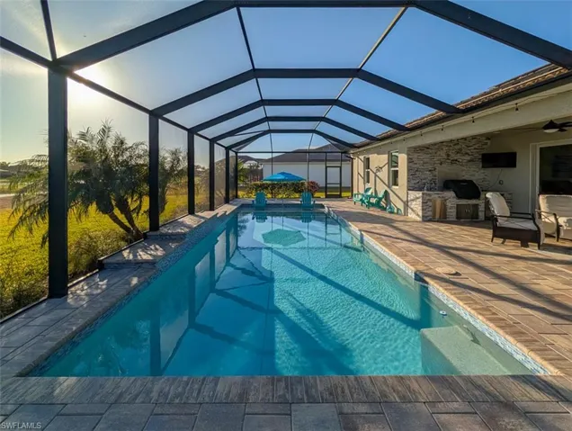 Outdoor pool with a lanai, a sunroom, and a patio