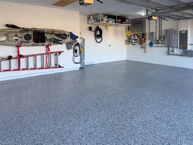 Garage featuring electric panel and a garage door opener