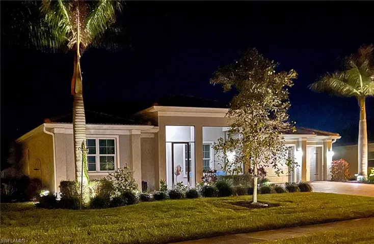 View of front of property with a lawn, stucco siding, and concrete driveway