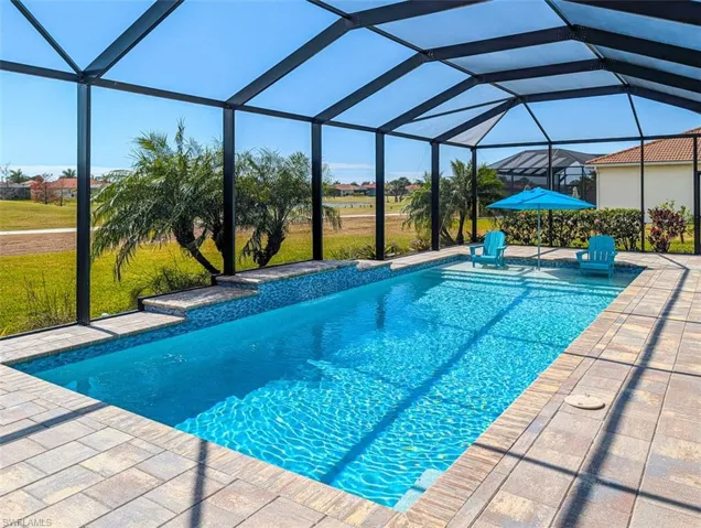 Swimming pool featuring a yard, a sunroom, a lanai, and a patio area