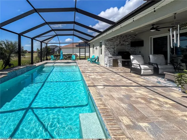 Swimming pool featuring a sunroom, a lanai, and a patio area