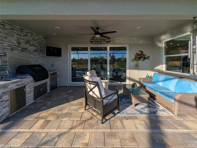 View of patio featuring an outdoor kitchen with living area and ceiling fan
