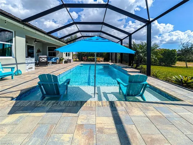 Outdoor pool with a patio area, a sunroom, outdoor furniture, and a lanai