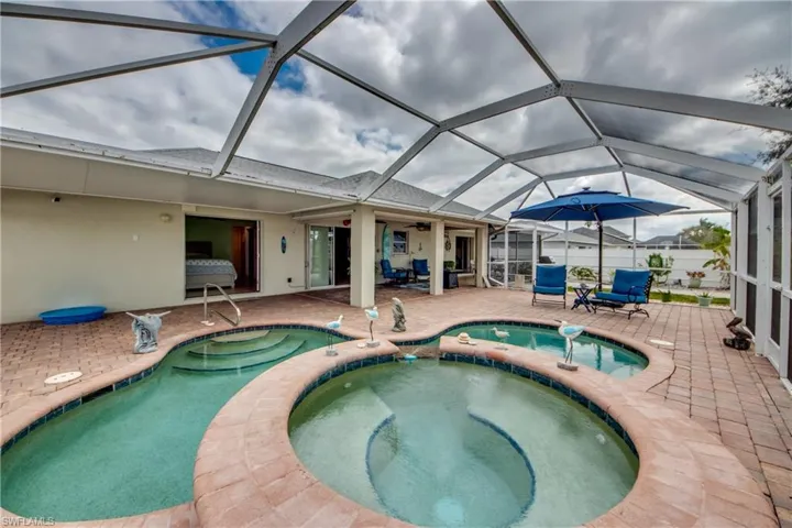 View of pool featuring an in ground hot tub, a patio, and glass enclosure