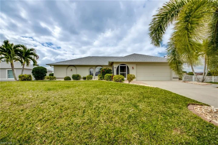 Single story home featuring a garage and a front yard