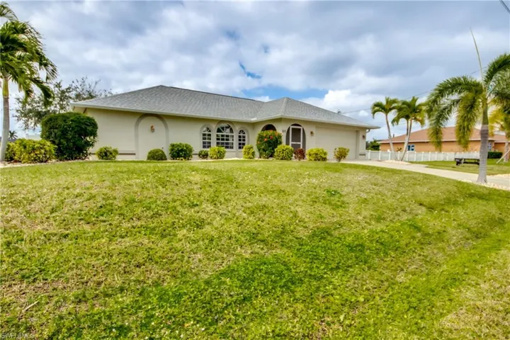 Single story home with a garage and a front lawn