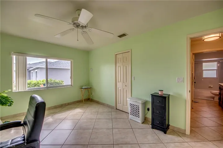 Unfurnished office with plenty of natural light, light tile patterned floors, and ceiling fan