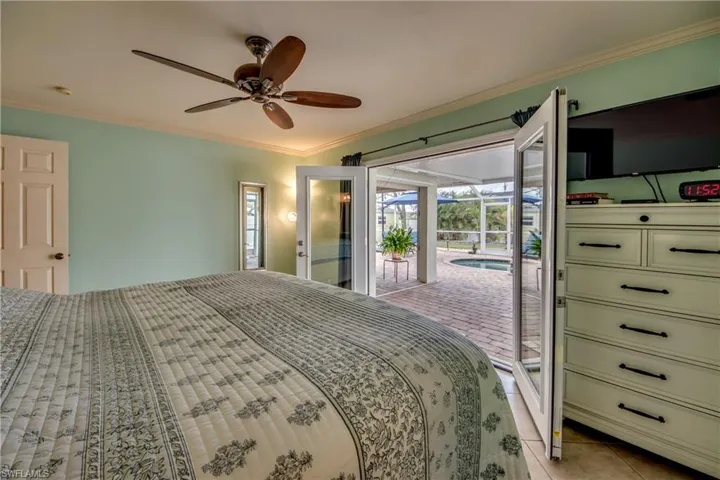 Tiled bedroom with crown molding, access to outside, and ceiling fan