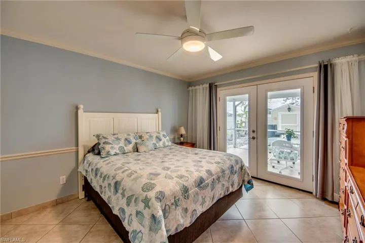Bedroom featuring french doors, light tile patterned flooring, crown molding, ceiling fan, and access to exterior