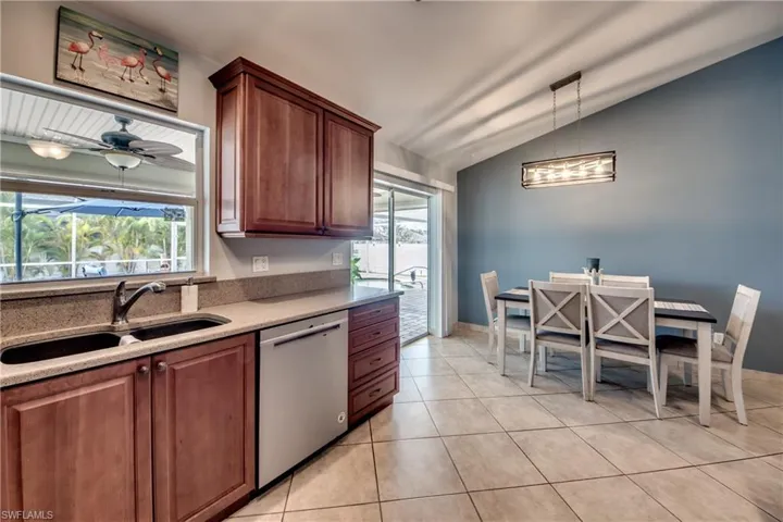 Kitchen with sink, decorative light fixtures, a wealth of natural light, and stainless steel dishwasher