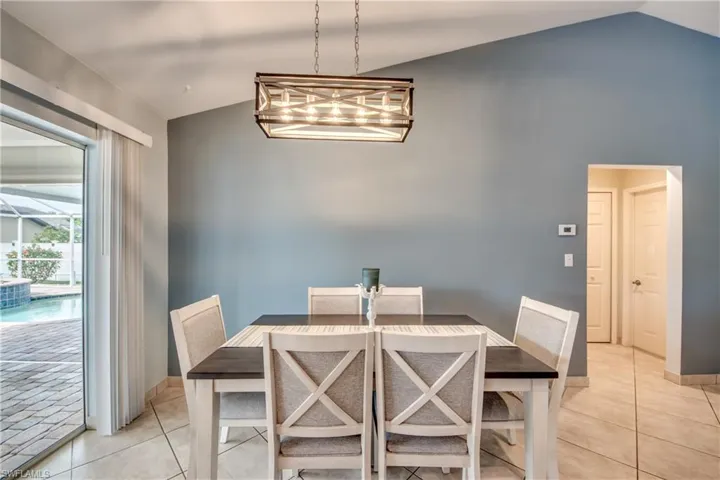 Dining space featuring vaulted ceiling and light tile patterned floors