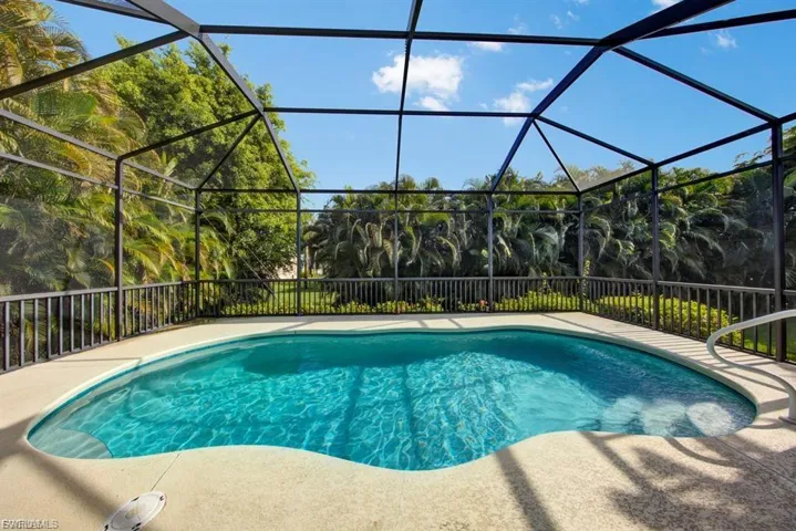 View of swimming pool featuring glass enclosure