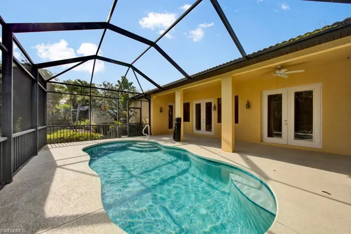 Swimming pool featuring french doors, a patio, a ceiling fan, and a lanai