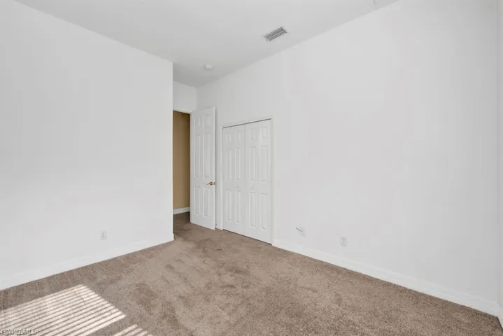 Carpeted empty room featuring baseboards