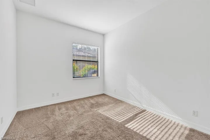 Unfurnished room featuring carpet floors and baseboards