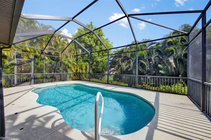 Swimming pool featuring a patio area and glass enclosure