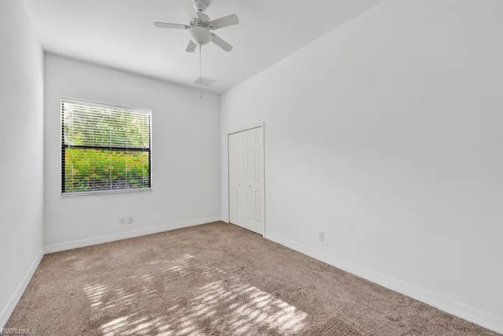 Empty room with carpet floors and a ceiling fan