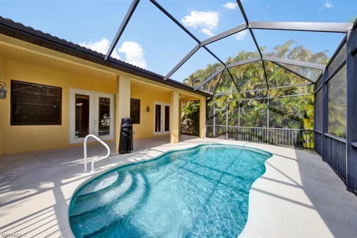 Outdoor pool featuring french doors and a patio